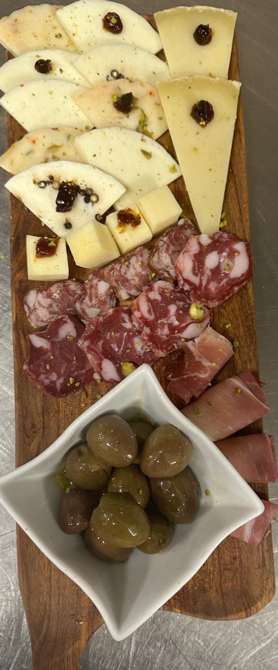 Tagliere di formaggi con marmellata, salamella e olive